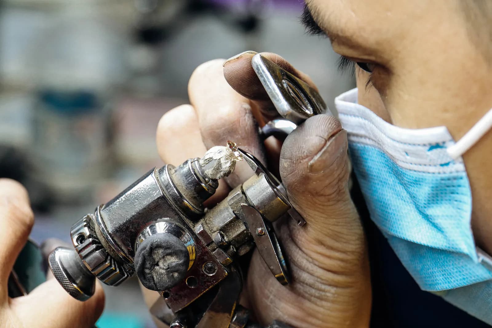 Jeweler manually setting a stone under magnification