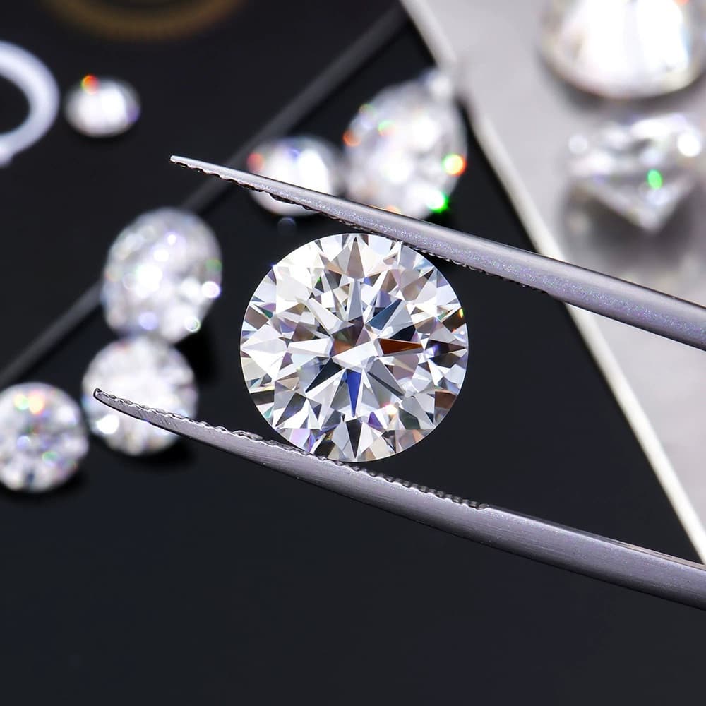 Round moissanite stone held by tweezers